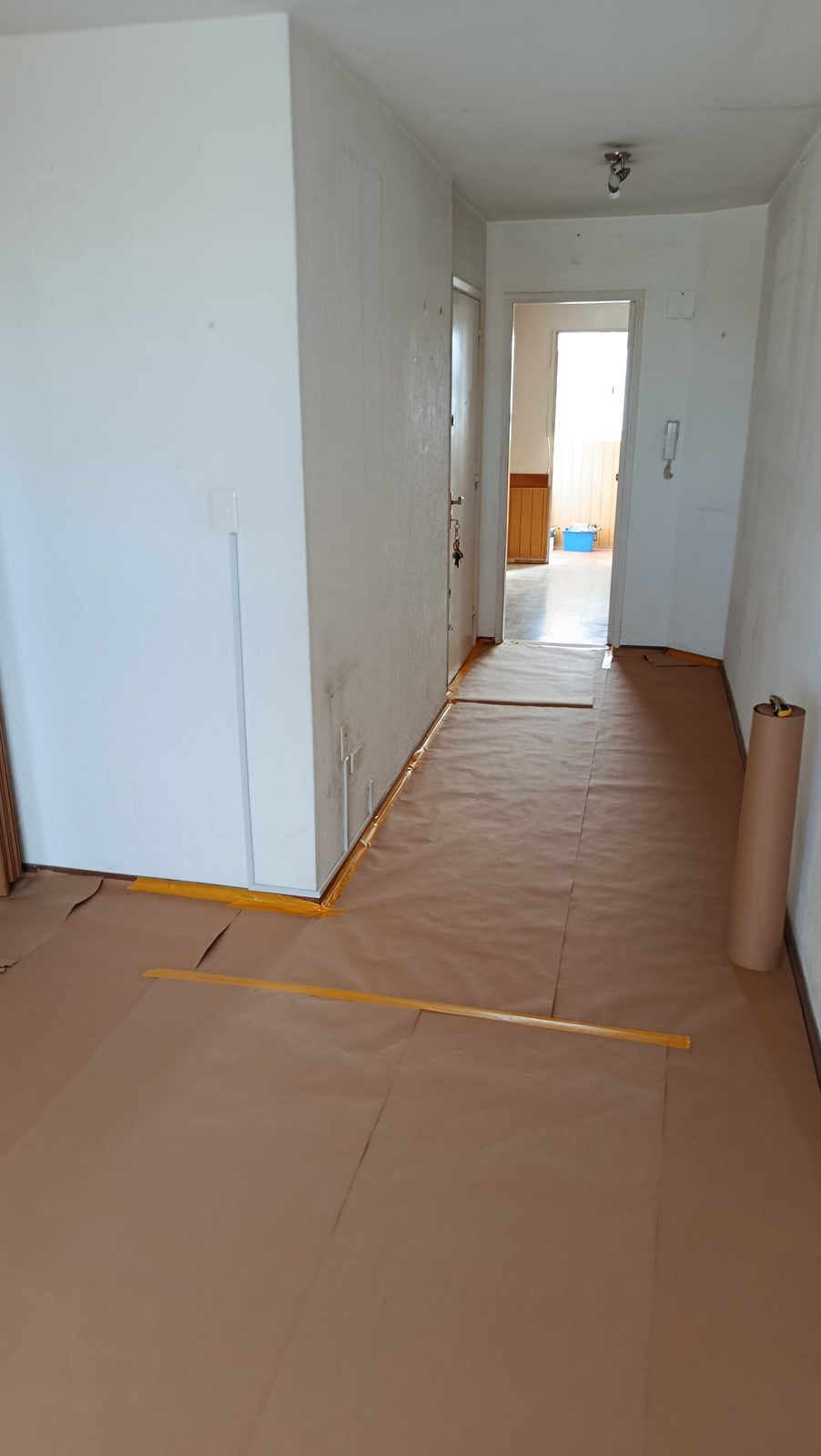 Piso y zócalos protegidos con papel y cinta antes de pintar